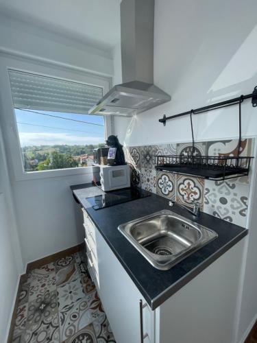 a small kitchen with a sink and a window at La casuca de Candela in Santillana del Mar
