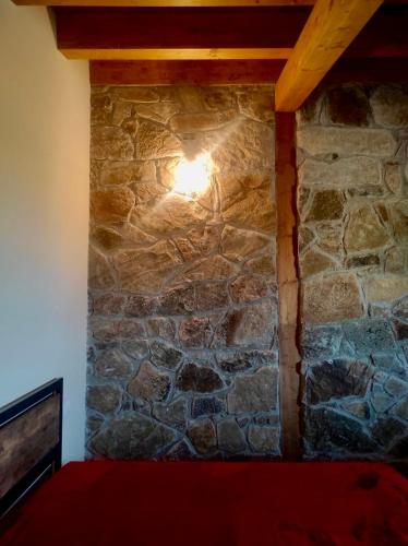 a stone wall in a room with a light on it at MonteSoprano Agriturismo - Resort - Spa - Gym -Camping - Suite in Capizzi