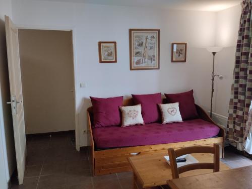 - un canapé violet dans le salon avec une table dans l'établissement Entre FAUNE, LAC et MONTAGNE, aux Angles