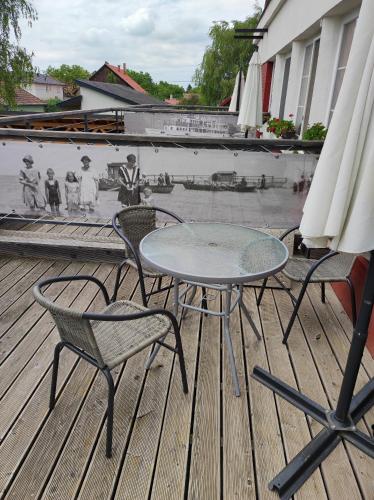 a table and two chairs and an umbrella on a deck at Zamárdi Trafóház in Zamárdi