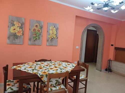 a dining room with a table and four paintings on the wall at Il Doganiere in Montecchio