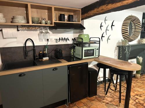 - une cuisine avec un comptoir, un four micro-ondes et une table dans l'établissement Charmant studio en hyper centre, à Orléans