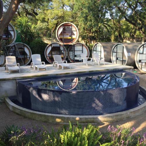 a large pool with chairs and a table and a fire pit at Tubohotel in Tepoztlán