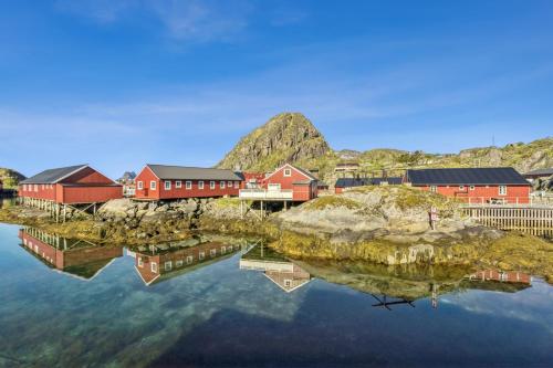 a small town with red buildings on a body of water at Waterfront Twin Cabin in Stamsund