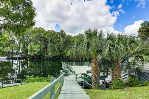 a wooden dock next to a lake with palm trees at Boathouse and Dock Riverfront Dunnellon Getaway! in Dunnellon