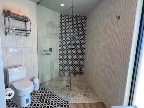 a bathroom with a toilet and a glass shower at Valle Soléa in El Porvenir