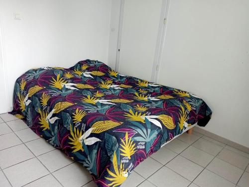 Ce lit se trouve dans un dortoir doté d'une couverture colorée. dans l'établissement Abillard sylvia, à Commequiers