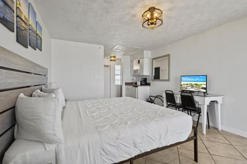 a bedroom with a bed and a desk with chairs at Ocean View Hotel Room with Balcony- King Bed #25 in Fort Pierce