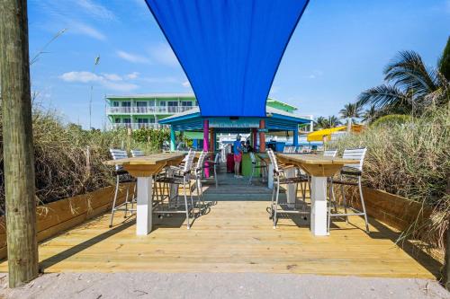 a group of tables and chairs on a boardwalk at Oceanfront Inn, Standard, King Bed, Inlet View #15 in Fort Pierce