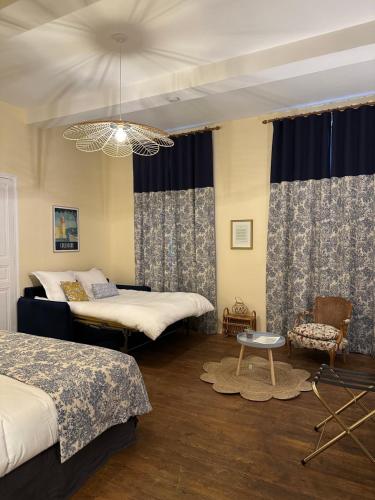 a bedroom with two beds and a chandelier at L'enthousiasme in Prades