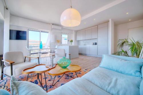 un salon avec un canapé et une table dans l'établissement Downtown Cannes 2BR with AC & Terrace w Sea View - BENAKEY, à Cannes