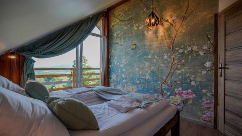 a bedroom with a bed in front of a window at Domek na Modyni, Dwa domki z ruską balią i sauną in Łącko