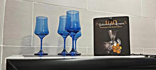 four blue wine glasses on a shelf next to a box at Elegancia, Calor y Comodidad in Melgar