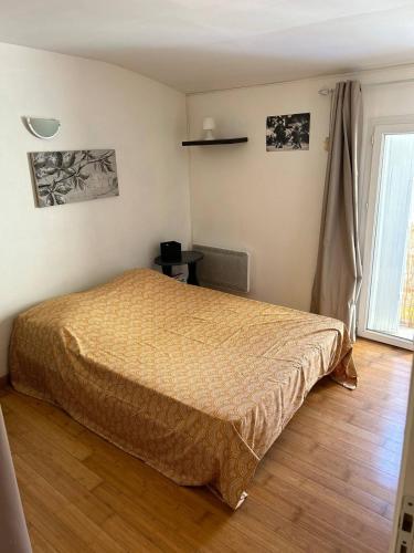 une chambre avec un lit et un parquet dans l'établissement Appart Yucca, à Lézignan-Corbières