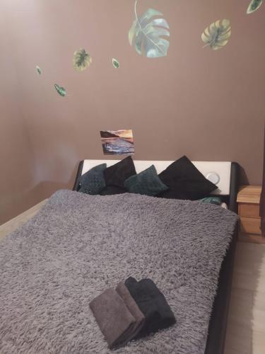 a bedroom with a bed with gray sheets and pillows at Bajkowy Dom in Mielno