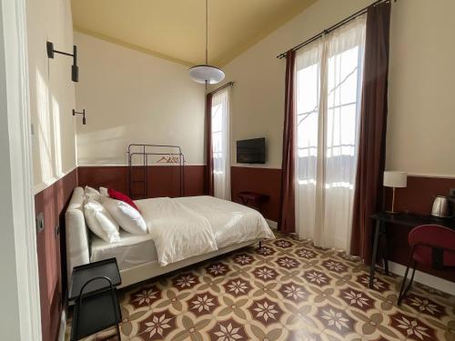 a bedroom with a bed and a table and a window at Maison Ines Luxury B&B in Messina