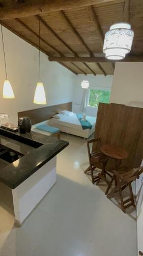 cocina con mesa, silla y cama en Recanto Mucugê, en Porto Seguro