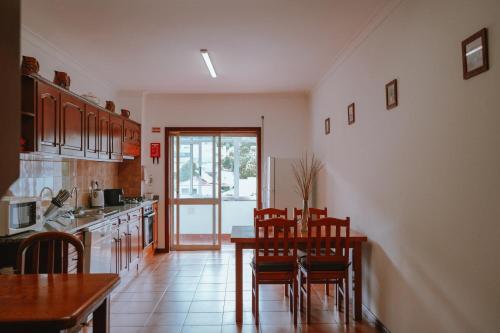 a kitchen with a table and chairs and a dining room at Férias em Cerveira in Vila Nova de Cerveira
