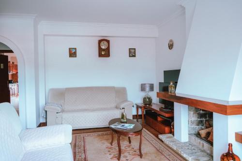 a living room with a white couch and a fireplace at Férias em Cerveira in Vila Nova de Cerveira