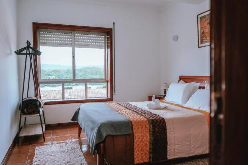 a bedroom with a bed and a large window at Férias em Cerveira in Vila Nova de Cerveira