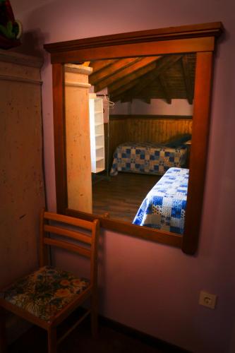 a mirror in a room with a bed in a bedroom at Casa el Fanoso in Luarca