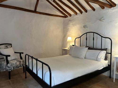 a bedroom with a bed and a chair at Las casillas de la Villa: TANGO in Montefrío