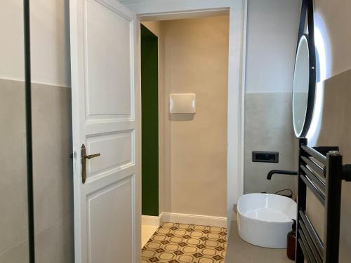 a bathroom with a white door and a sink at Maison Ines Luxury B&B in Messina