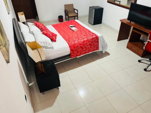 a bedroom with a bed with a red comforter at Hotel Andes in Florencia