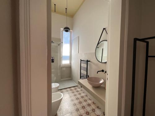 a bathroom with two toilets and a sink at Maison Ines Luxury B&B in Messina