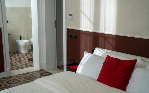 a bedroom with a bed with a red pillow at Maison Ines Luxury B&B in Messina