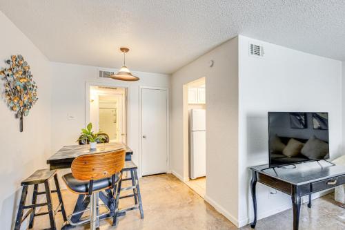 a kitchen with a bar and a table and a television at Dallas Condo in Walkable Knox Street District! in Dallas