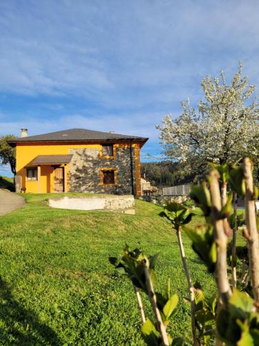 a house in a yard with a green field at Casa el Fanoso in Luarca