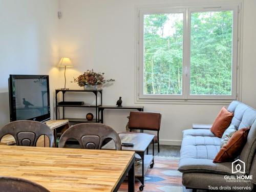 un salon avec un canapé et une télévision dans l'établissement Les Chênes - Climatisation - Spacieux - Nature, à Boigny-sur Bionne