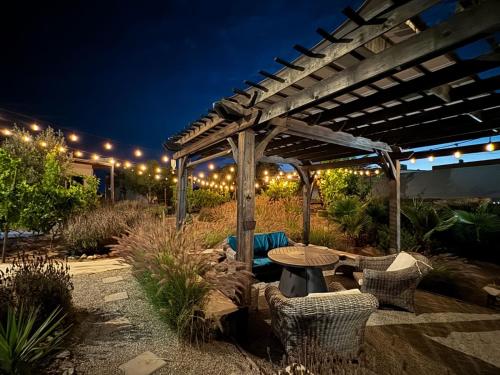 a patio with a table and chairs under a pergola at Rincón del Corazón in Valle de Guadalupe