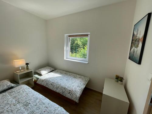 ein Schlafzimmer mit zwei Betten und einem Fenster in der Unterkunft AURUM resort in Štiavnické Bane