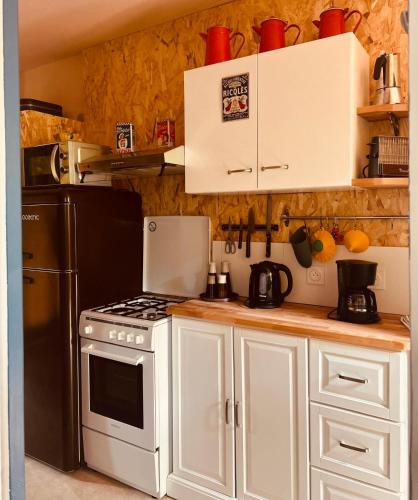 a kitchen with white cabinets and a stove and a refrigerator at Casa Bauxells in Sahorre