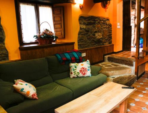 a living room with a green couch and a table at Casa el Fanoso in Luarca