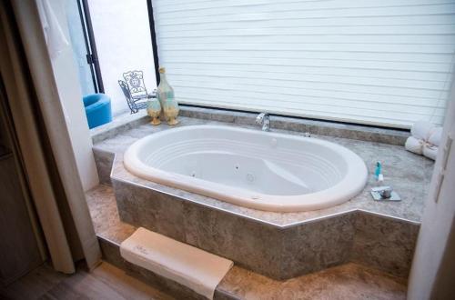 a large bath tub in a bathroom with a window at Centenario Los Arroyitos in Bernal