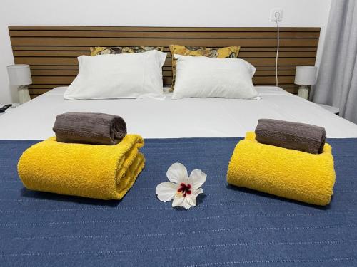 a bed with two towels and a flower on it at Porta Nova Guesthouse by R-Tex in Tavira