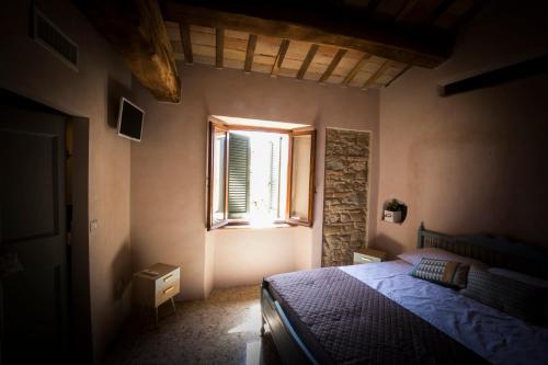 a bedroom with a bed and a window at Il Vicoletto di BIBI - B&B in Staffolo