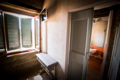 a bathroom with a window and a bench next to a sink at Il Vicoletto di BIBI - B&B in Staffolo