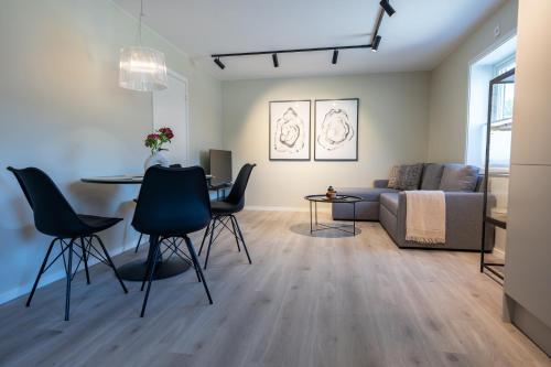 a living room with a table and chairs and a couch at M&R Lofoten Apartment in Svolvær