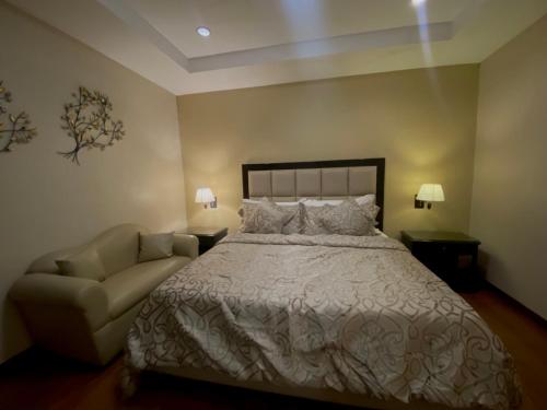 a bedroom with a large bed and a couch at Prism Hotel in Angeles
