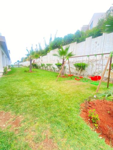 a yard with a net in the grass at Appartement en bord de mer in Pont Blondin