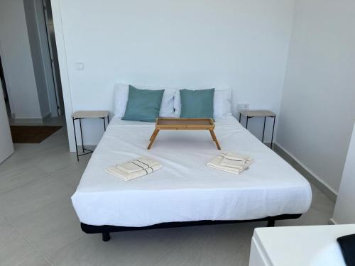 a bed with a wooden tray on top of it at Modern apartment sea view with private jacuzzi in Villajoyosa