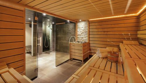 a sauna with a shower and a sink at Morosani Posthotel in Davos