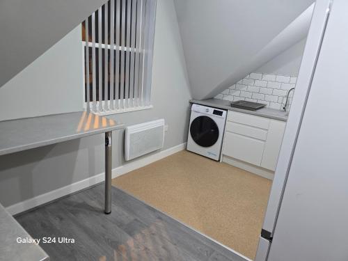 Una pequeña cocina blanca con lavadora y secadora. en 2 bedrooms apartment, en Birmingham