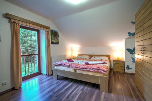 um quarto com uma cama e uma grande janela em Apartmány Barto21 em Bartošovice v Orlických Horách