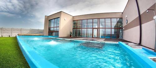 a large swimming pool in front of a house at Drevenice Rapovce Novolandia in Rapovce