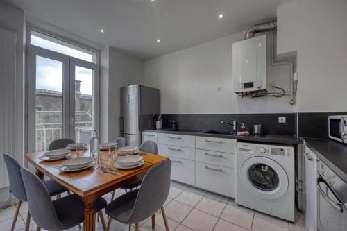une cuisine avec une table et des chaises et une cuisine avec une machine à laver dans l'établissement Le Berriat - Gare - Palais de Justice, à Grenoble